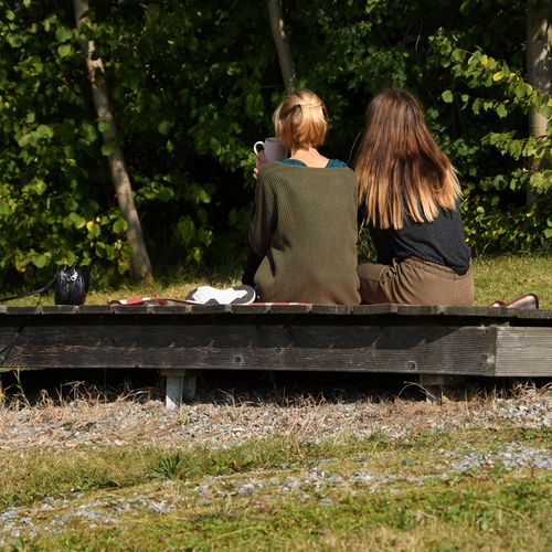 Zwei Frauen sitzen auf einer Bank